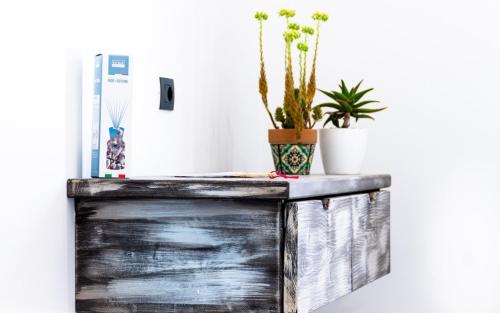 a wooden table with a refrigerator and plants on it at Isola dei poeti in Marzamemi
