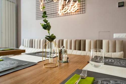 a vase with a plant in it sitting on a table at Hotel Manor in Mamaia Nord