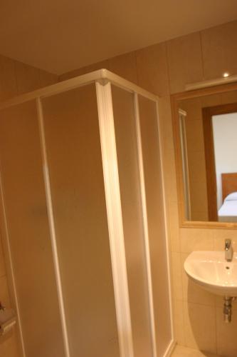 a bathroom with a shower and a sink at Albergue La Encina in Hospital de Órbigo