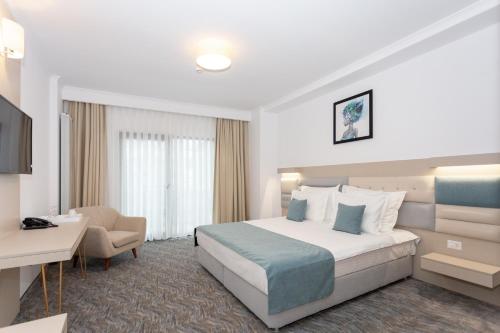 a hotel room with a bed and a chair at Hotel Manor in Mamaia Nord