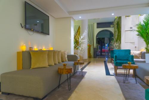 WINDSOR HOTEL CITY CENTER في الدار البيضاء: غرفة معيشة مع أريكة وبعض الكراسي