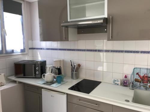 a kitchen with a sink and a microwave at Fishermen's Friend in Port-en-Bessin-Huppain