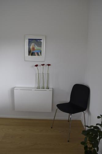 a black chair in a room with a white wall at Fredensholm Annex in Skanderborg
