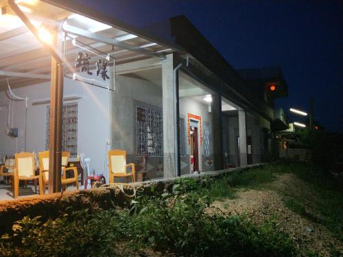 a building with a table and chairs outside at night at 琉漾民宿 in Xiaoliuqiu