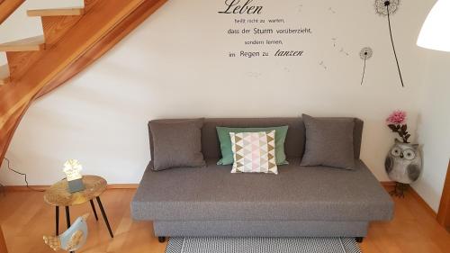 a couch in a living room with a wall at Ferienwohnung Manuela in Adnet