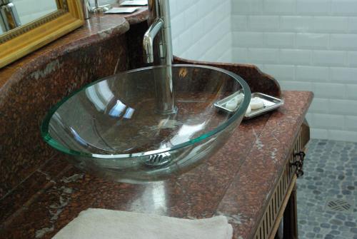 Veuil弗伊城堡住宿加早餐旅馆的浴室内一个吧台上的玻璃碗水槽
