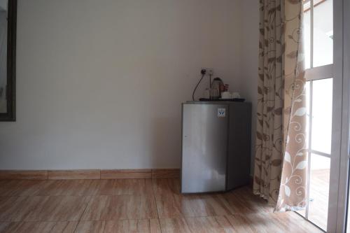 a small refrigerator in a room next to a window at Chalet Bamboo Vert in La Digue