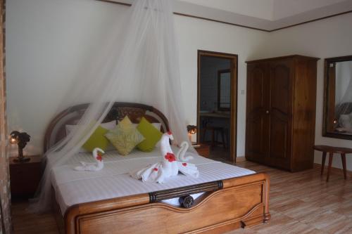 a bedroom with a bed with stuffed animals on it at Chalet Bamboo Vert in La Digue