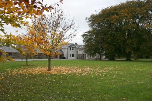 a tree in a field in front of a house at Coolanowle Self Catering Holiday Accommodation in Carlow
