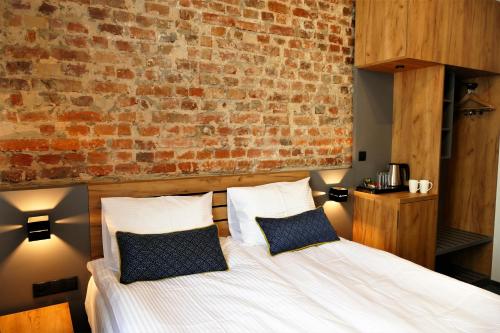 a bedroom with a bed and a brick wall at Hotel Mokotów in Warsaw