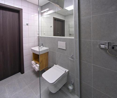 a bathroom with a toilet and a sink and a shower at S7 Hotel in Kielce