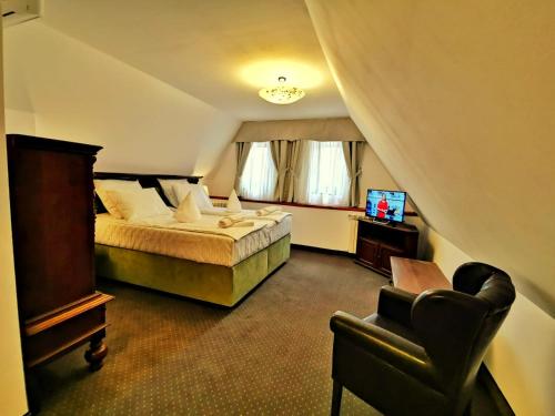 a hotel room with a bed and a chair at Casa Kuhn in Sighişoara