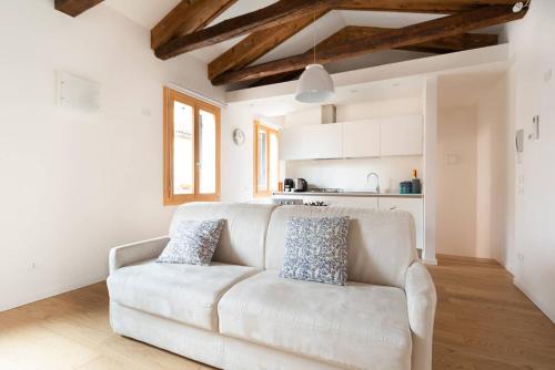 uma sala de estar com um sofá branco e uma cozinha em Ve-nice Suite Casa Teresa C881 em Veneza
