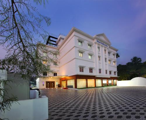 a large white building with a lot of windows at Hotel Sidhartha Chalakudy in Kizhake Chālakudi