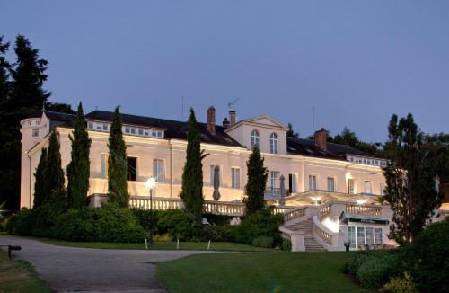 a large white house with a staircase in front of it at Domaine et Golf de Vaugouard - La Maison Younan in Fontenay-sur-Loing