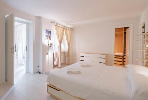 una camera bianca con un grande letto e un comò di Porta Nuova Apt X6 with Balcony a Torino