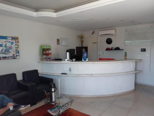 a bar in a room with a couch and a counter at Hotel Master in Primavera do Leste