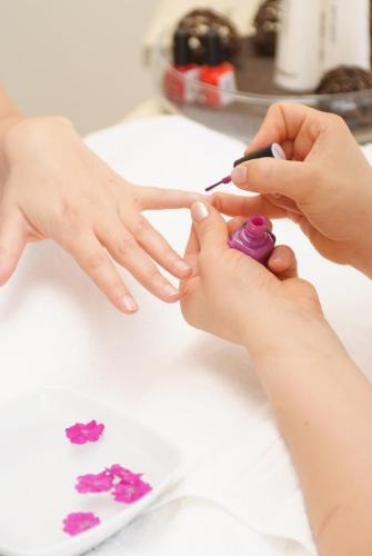 a child getting their nails painted with purple nail polish at Hotel Lahnschleife in Weilburg