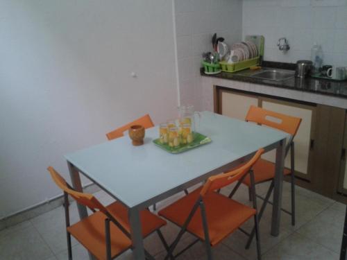 una mesa con sillas naranjas en la cocina en Falow, en Las Palmas de Gran Canaria