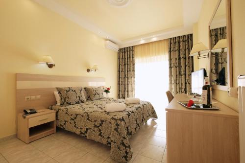 a bedroom with a bed and a dresser and a television at Hotel Diamantidis in Myrina