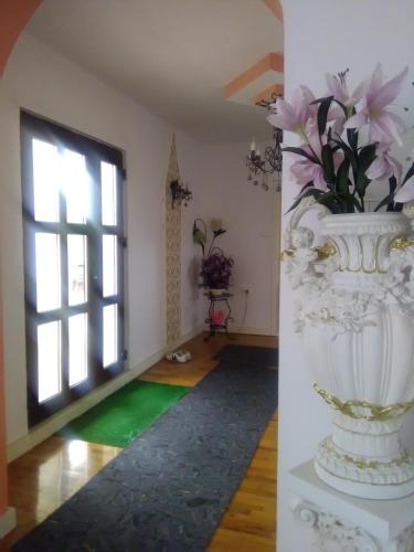 a room with a large white vase with flowers in it at CAZARE LA ESPAÑOLA in Haţeg