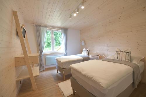 a room with two beds and a chair and a window at NORDIK 1496 in Vysoké Tatry