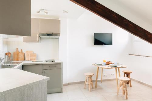 - une cuisine blanche avec une table et des tabourets dans l'établissement Adorable apartment in Nice downtown, à Nice
