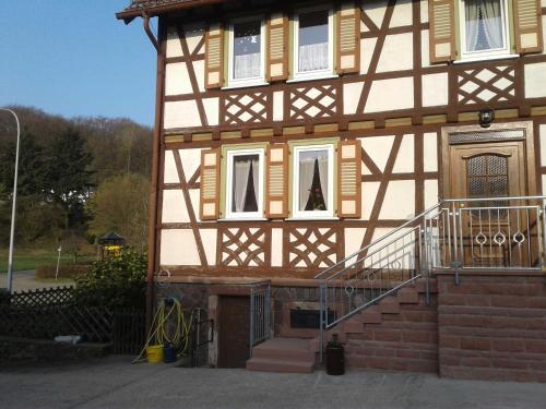 a house with a staircase in front of it at Kreuzdellenhof _ Ferienwohnung in Hembach