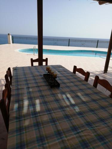 a table with chairs and a view of a pool at Hill of Calm in Triopetra