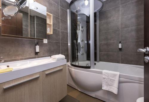 y baño con bañera, aseo y lavamanos. en Zenitude Swiss Apparthotels, en Ferney-Voltaire