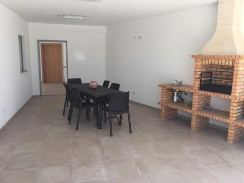 a dining room with a table and chairs and a fireplace at Casa Luna in Pataias