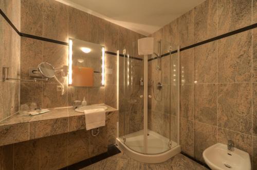 a bathroom with a shower and a sink and a toilet at Hotel Lahnschleife in Weilburg