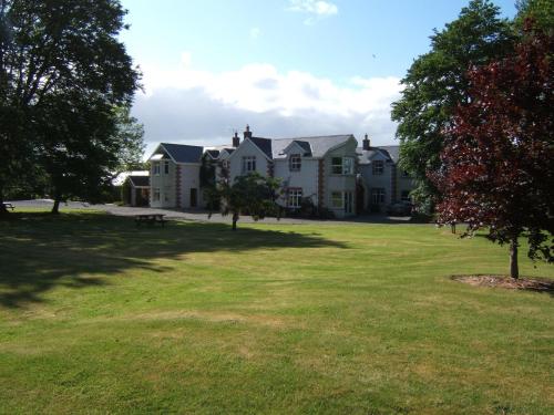 a large house with a large yard with trees at Coolanowle Self Catering Holiday Accommodation in Carlow