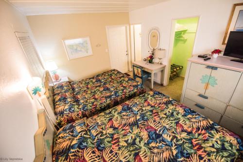 Cette chambre comprend un lit, un bureau et une télévision. dans l'établissement Ocean Inn, à Hollywood
