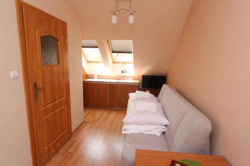 ein kleines Wohnzimmer mit einem Sofa und einer Küche in der Unterkunft Gucio Domek Gościnny in Rewal