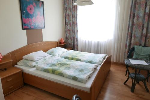 a bed in a small room with a window at Gasthof Pension „Zur Hammerschmiede“ in Drosendorf Altstadt