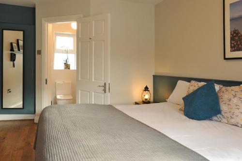 a bedroom with a large white bed with blue pillows at The Gateway Lodge in Donegal