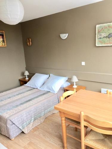 une chambre avec un lit et une table en bois dans l'établissement RÉSID BEC DE L AIGLE Studio 21 - LE LIORAN, à Laveissière