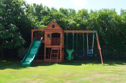 a playground with a slide and a swing at Hanger Down House Bed and Breakfast in Arundel