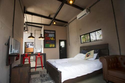 a bedroom with a bed and a table and a chair at The Cubes in Lusaka