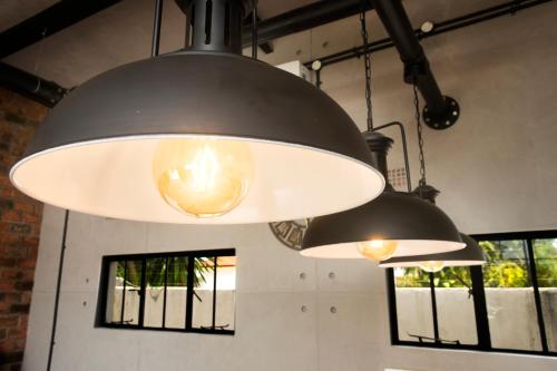 two lights hanging from a ceiling in a room with windows at The Cubes in Lusaka