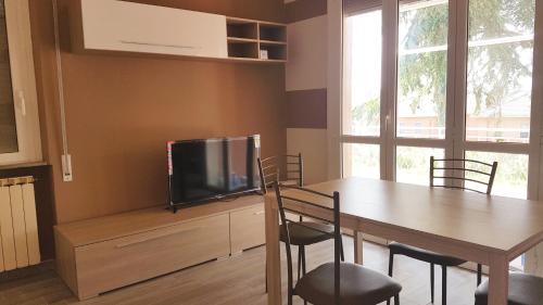 uma sala de jantar com uma mesa e uma televisão de ecrã plano em Apt. 7 - Villa dei Pini em Ameglia