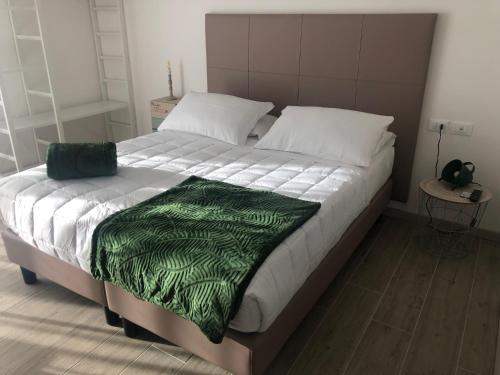 a large bed with a green blanket on it at Sole&Luna - Rooms in Eraclea