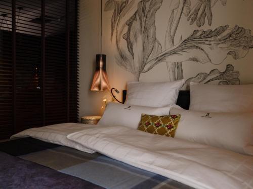 1 dormitorio con cama con almohadas blancas y papel pintado en Loft im Stadl, en Innervillgraten