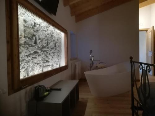 a bathroom with a tub and a large window at Hotel Albrici in San Bernardo