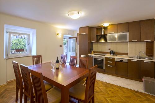 布德瓦的住宿－Apartment Kovacevic Old Town，厨房以及带木桌和椅子的用餐室。