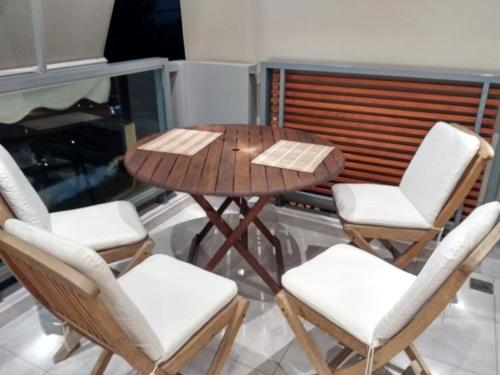 a wooden table and chairs on a balcony at Luxury apartment in the elite area in Athens