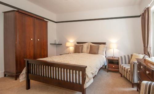 sypialnia z łóżkiem, szafką i krzesłem w obiekcie Natal House Bed & Breakfast w mieście Polperro