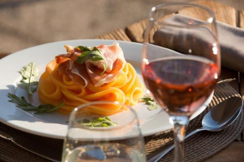 a white plate of food and a glass of wine at Domaine et Golf de Vaugouard - La Maison Younan in Fontenay-sur-Loing