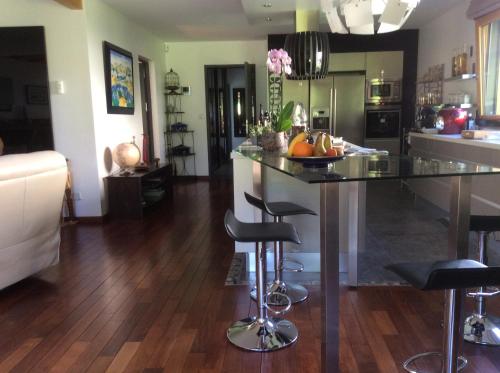 eine Küche und ein Wohnzimmer mit einer Theke und Stühlen in der Unterkunft Les Chambres D'oriane in Chessy